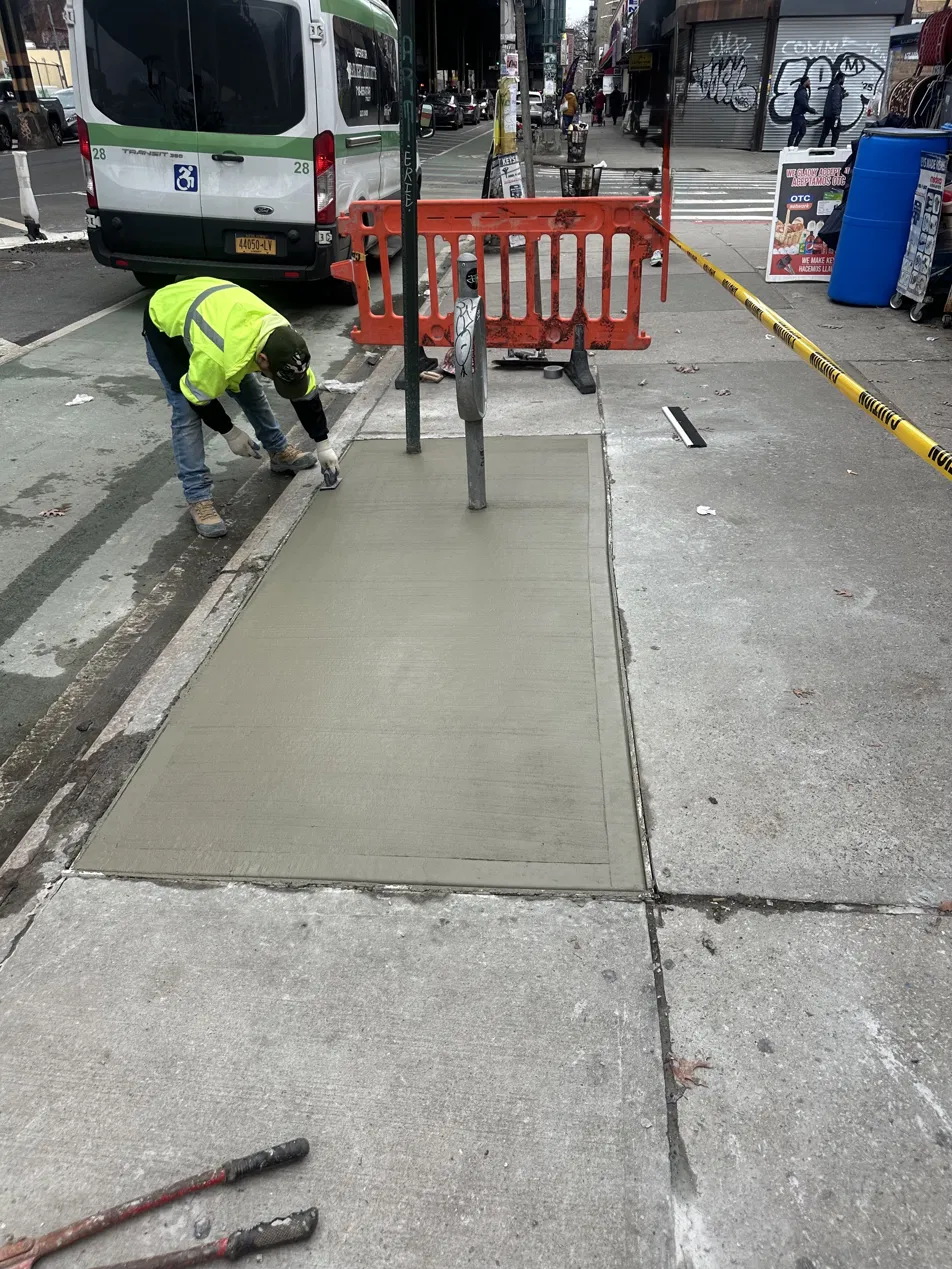 Concrete sidewalk work on a busy NYC street