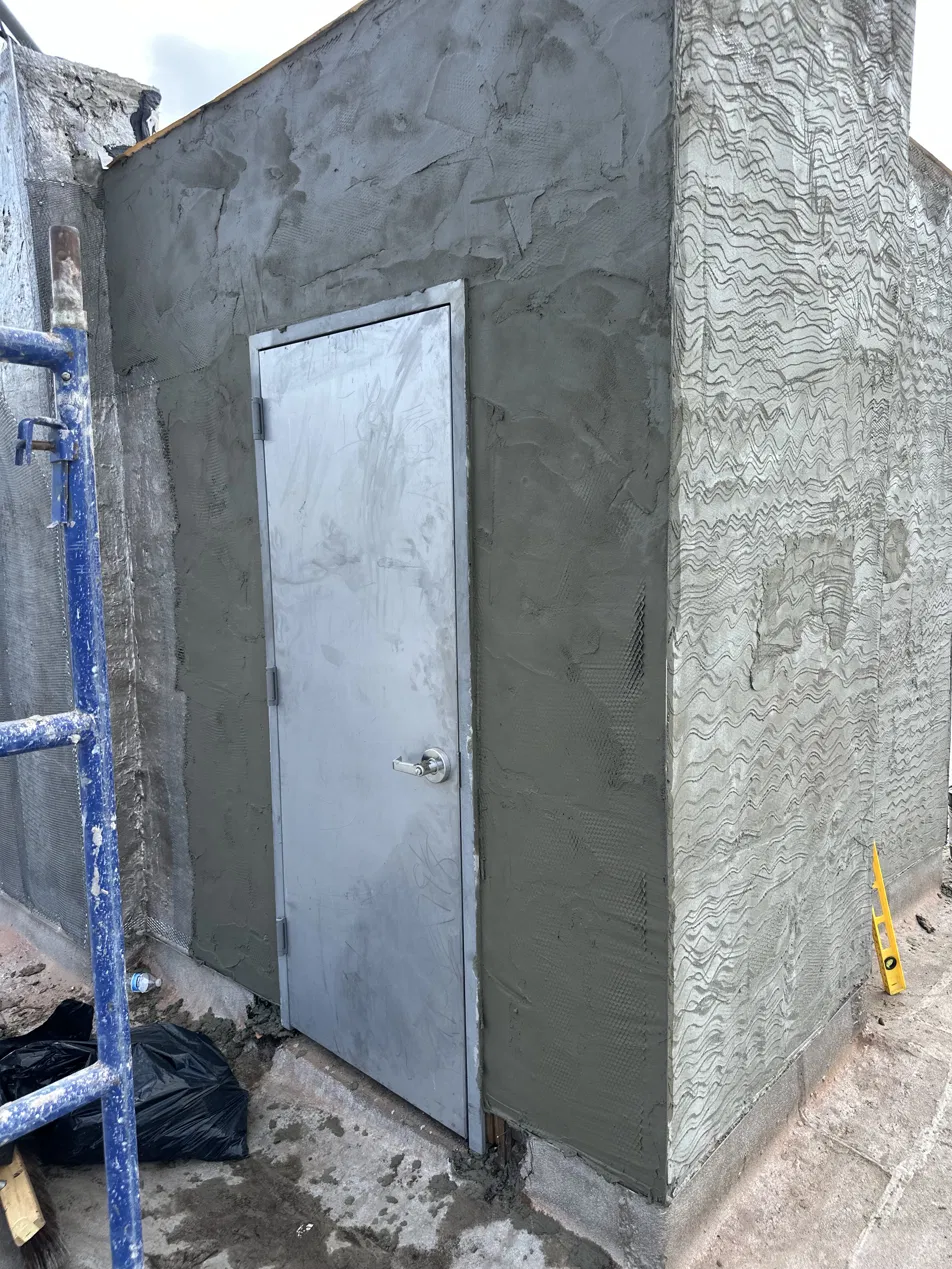 Completed stucco bulkhead with a new steel door