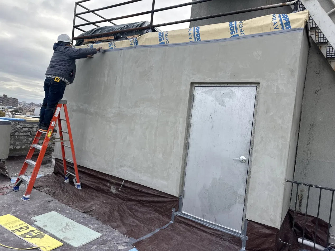 Stucco finishing on a rooftop parapet wall